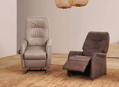Zwei Relaxsessel in Beige und Braun auf hellem Teppich unter zwei Hängeleuchten